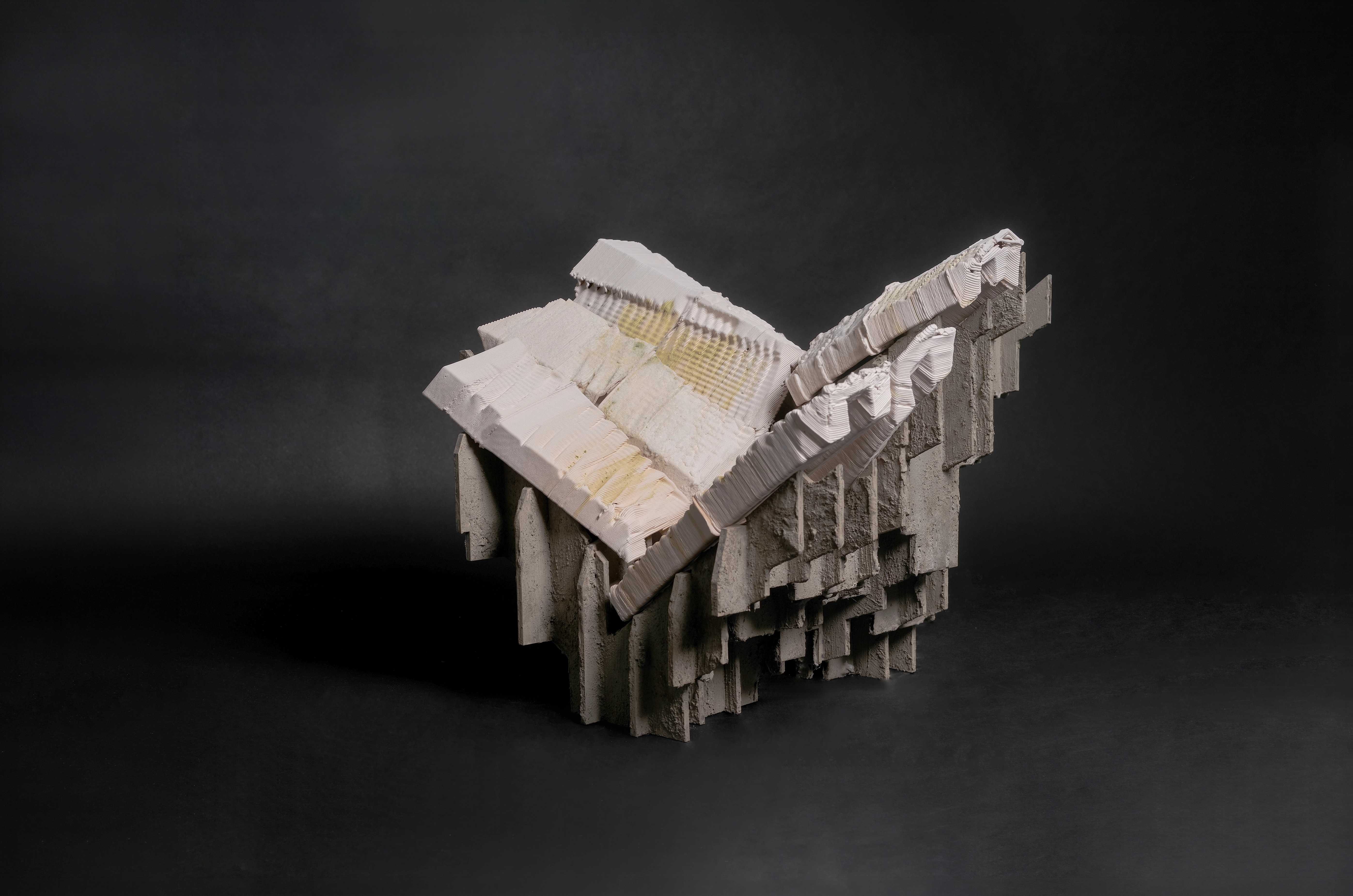 A single Halo-Tectonic piece: a layered ceramic-printed form with a pale ridged upper surface breaking over a rough stratified base, lit against a dark ground.